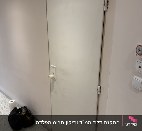 דלת עם מנעול וכלי עבודה על הרצפה